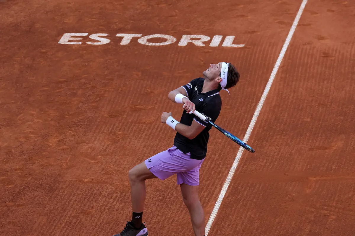 Casper Ruud a preparar uma pancada de direita em terra batida no Millennium Estoril Open, com a inscrição “Estoril” visível no court.