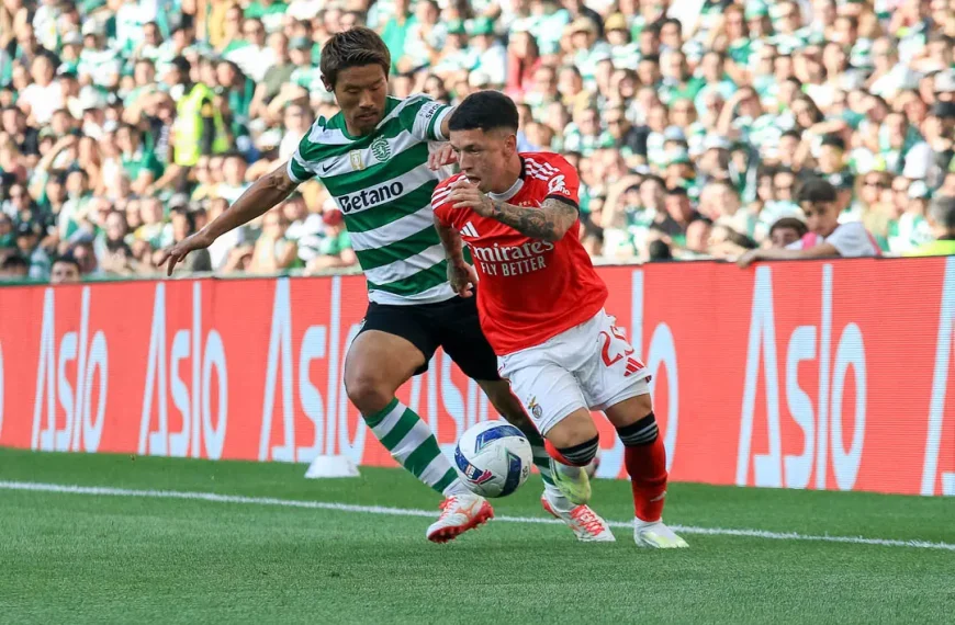 ogador do Benfica em condução de bola pressionado por jogador do Sporting no dérbi em Alvalade