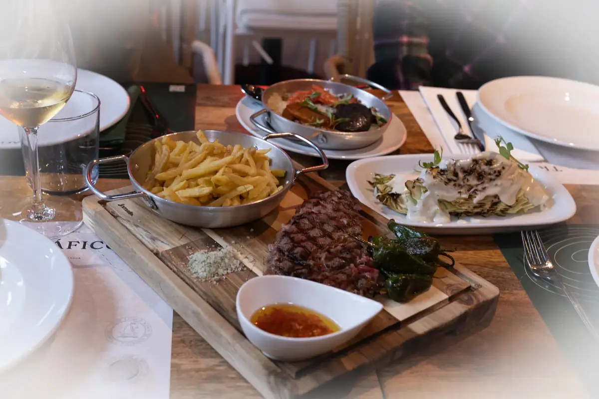 Bife grelhado servido com batatas fritas, legumes e molho num restaurante em Portugal