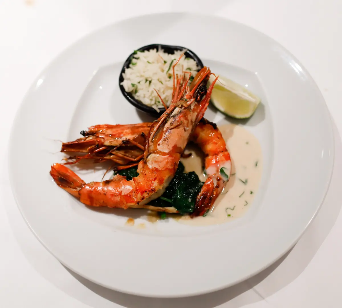 Camarão grelhado servido com arroz aromático e molho cremoso em restaurante fine dining em Portugal