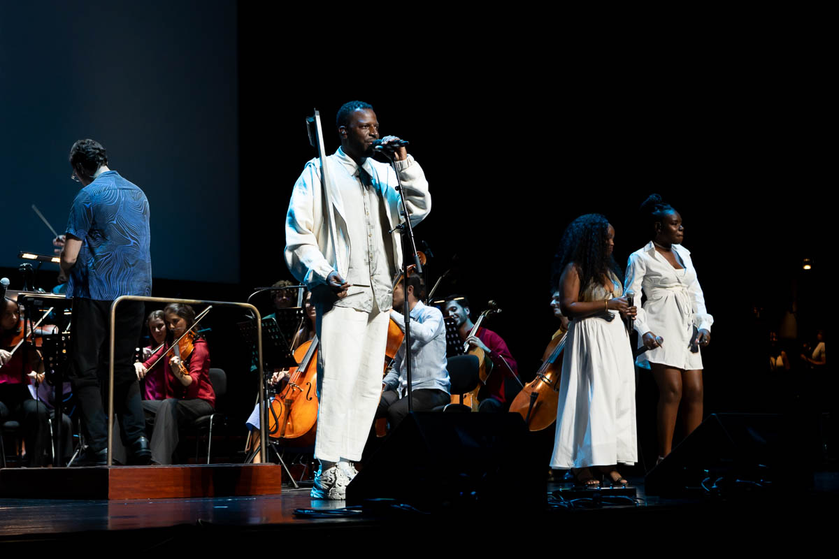 Dino D’Santiago em palco durante o concerto “Por um Mundo Nôbu” na Gulbenkian, em Lisboa, acompanhado por orquestra.