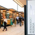 Feira do Livro de Lisboa com pavilhões de livros e visitantes a caminhar