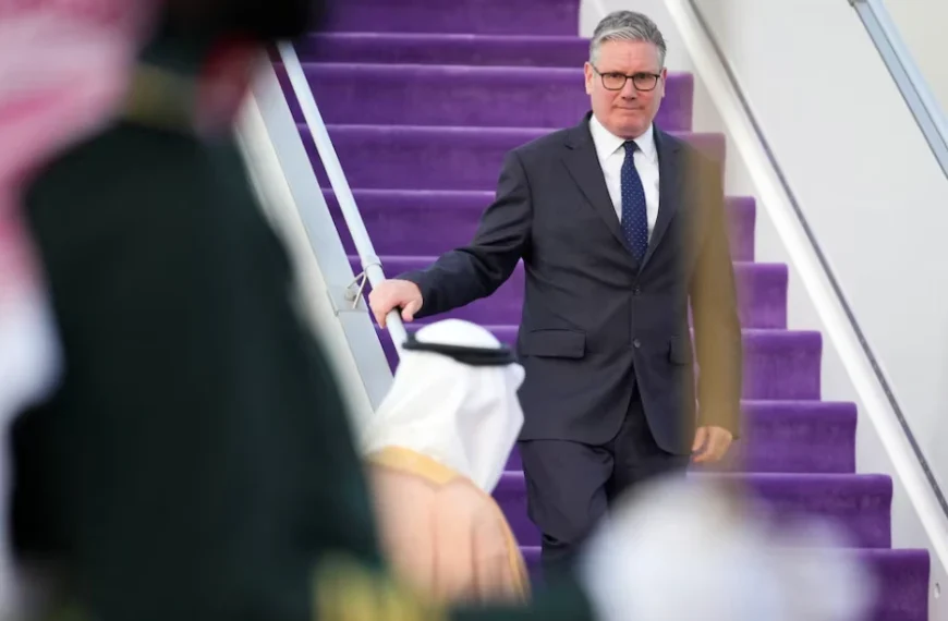 Keir Starmer desce escadas em chegada oficial durante contexto de crise internacional com o Irão