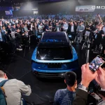 Evento internacional da OMODA JAECOO com multidão a observar novo modelo automóvel