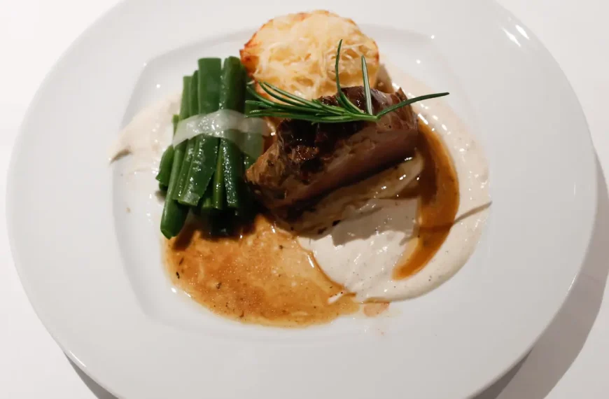 Prato de carne com feijão verde e molho cremoso em restaurante fine dining em Portugal