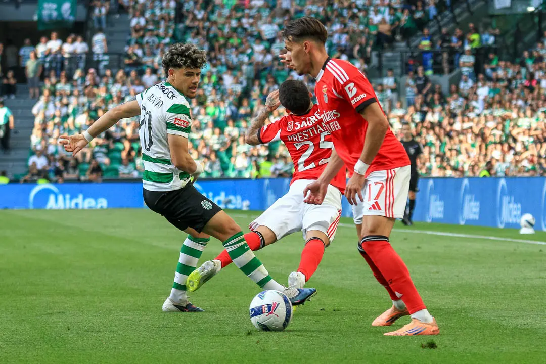Jogador do Sporting disputa bola com dois jogadores do Benfica durante o dérbi em Alvalade