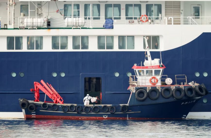 Equipas com fatos de proteção junto ao navio de cruzeiro afetado por surto de hantavírus em Tenerife