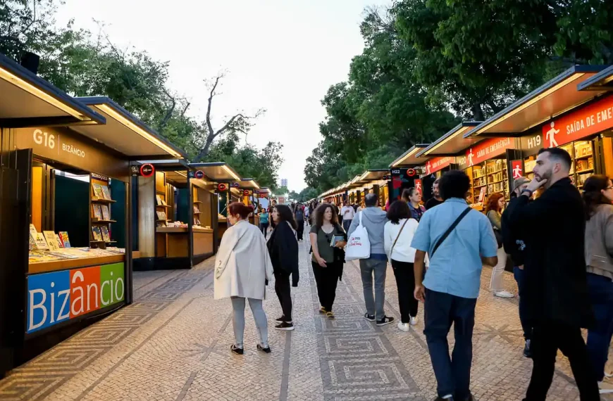 Visitantes na Feira do Livro de Lisboa 2026 no Parque Eduardo VII entre pavilhões de editoras e livrarias.