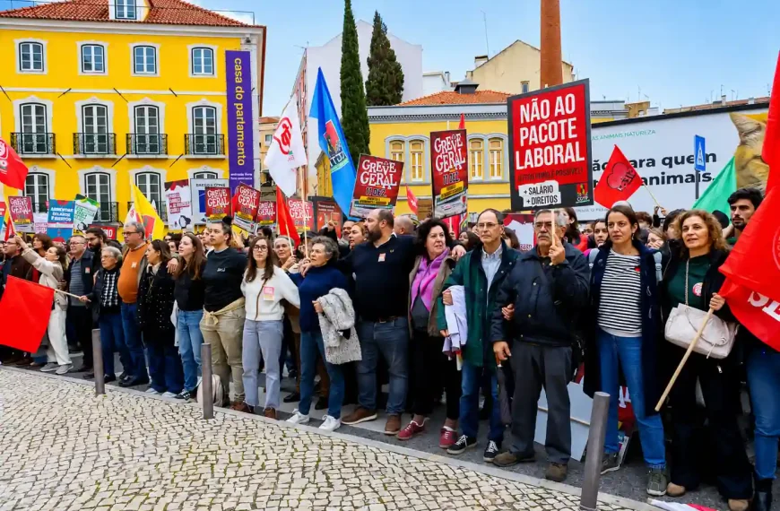 Manifestação em Lisboa com centenas de pessoas e cartazes contra medidas laborais e crise económica em Portugal.