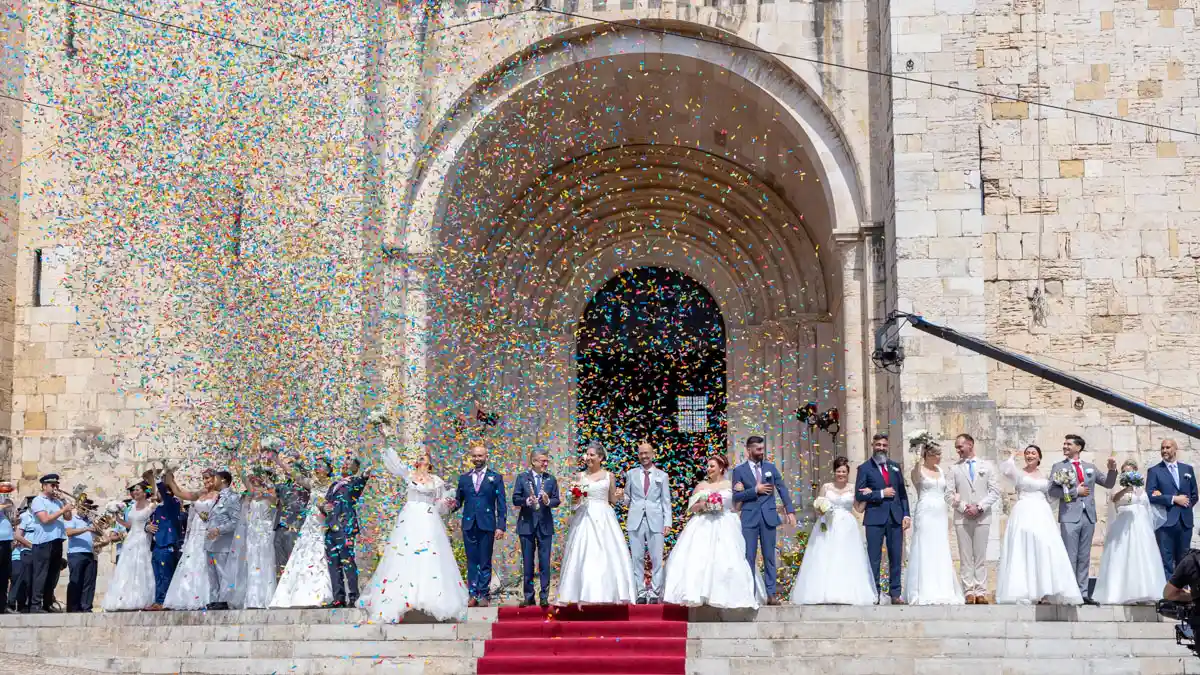 Os 11 casais dos Casamentos de Santo António 2026 celebram à saída da Sé de Lisboa sob uma chuva de confettis durante as Festas de Lisboa.