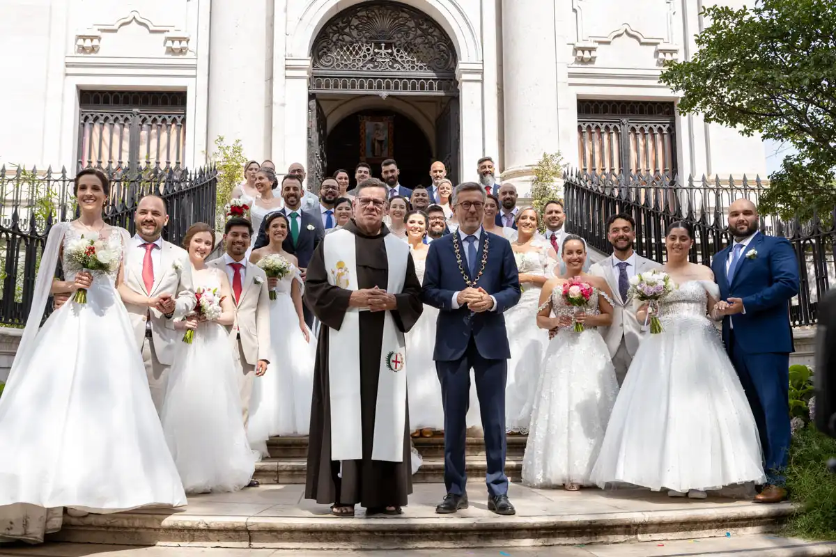 Os 16 casais dos Casamentos de Santo António 2026 posam para a fotografia oficial na escadaria da igreja de Santo António em Lisboa, acompanhados pelo celebrante e pelo presidente da Câmara Municipal de Lisboa, Carlos Moedas.