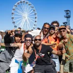 Grupo de festivaleiros posa para uma fotografia na Cidade do Rock durante o Rock in Rio Lisboa 2026.