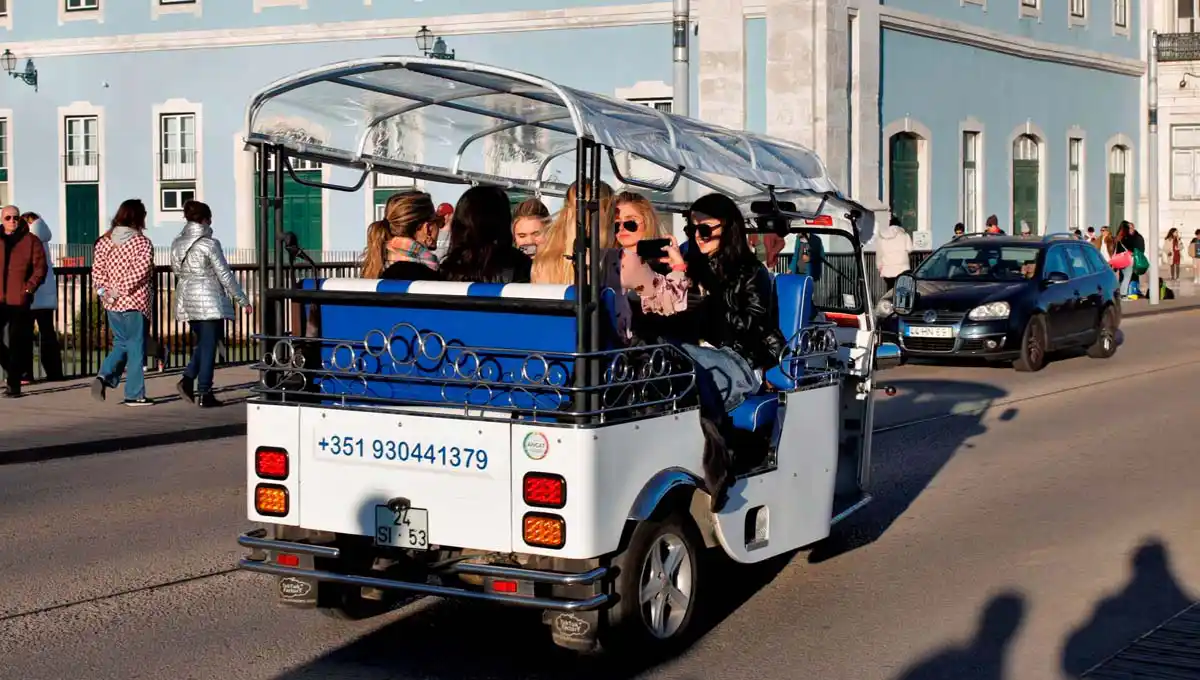 Turistas viajam num veículo turístico elétrico junto ao Museu Nacional de Arte Antiga, em Lisboa.