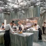 Interior do restaurante Enigma, em Barcelona, com a cozinha aberta e a equipa liderada por Albert Adrià a preparar o menu de degustação.