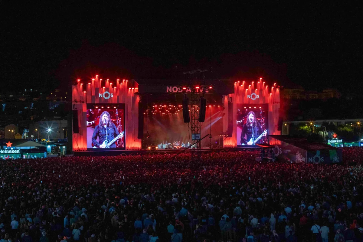 Os Foo Fighters atuam no palco principal do NOS Alive 2026 perante uma multidão no Passeio Marítimo de Algés.