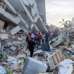 Equipas de resgate procuram sobreviventes entre os escombros de um edifício destruído pelo sismo em La Guaira, Venezuela.